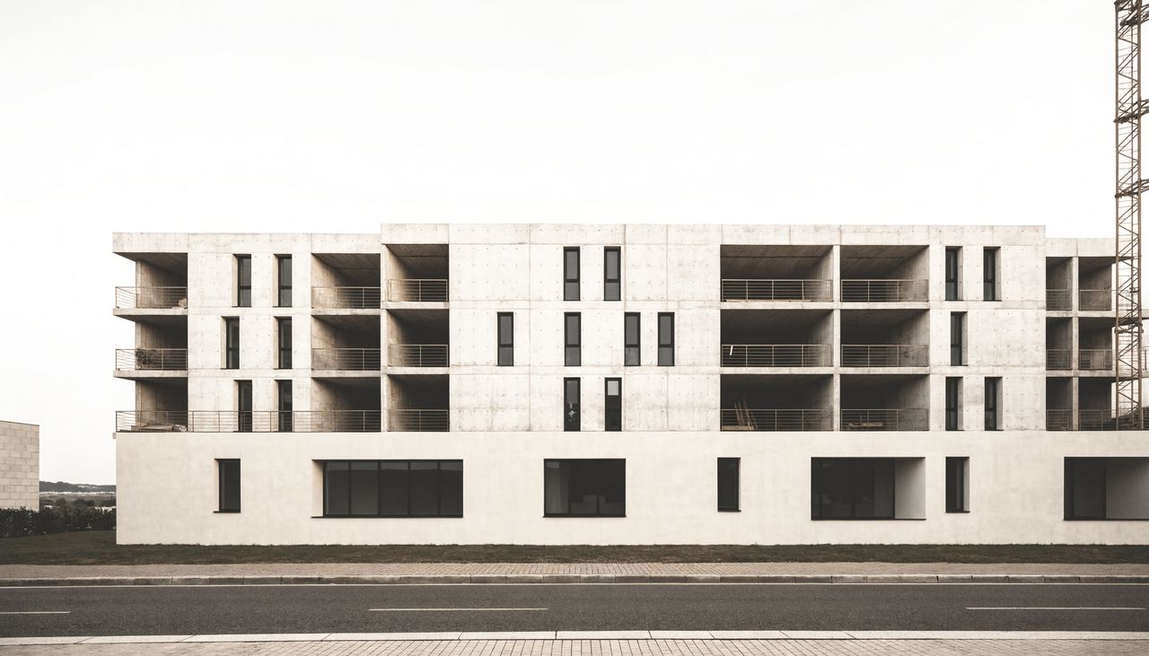 Edifício residencial em construção, com estrutura de concreto aparente nos pavimentos superiores